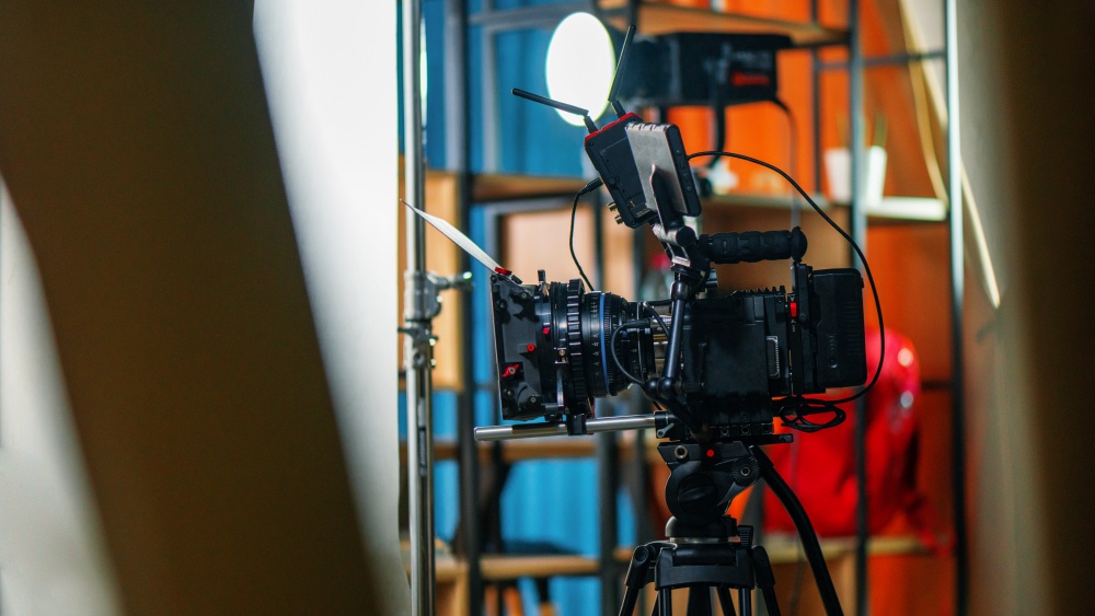 A professional camera on a tripod at a film set, interior on the background