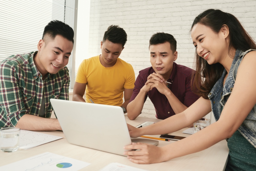 Group of young people watching presentation on laptop